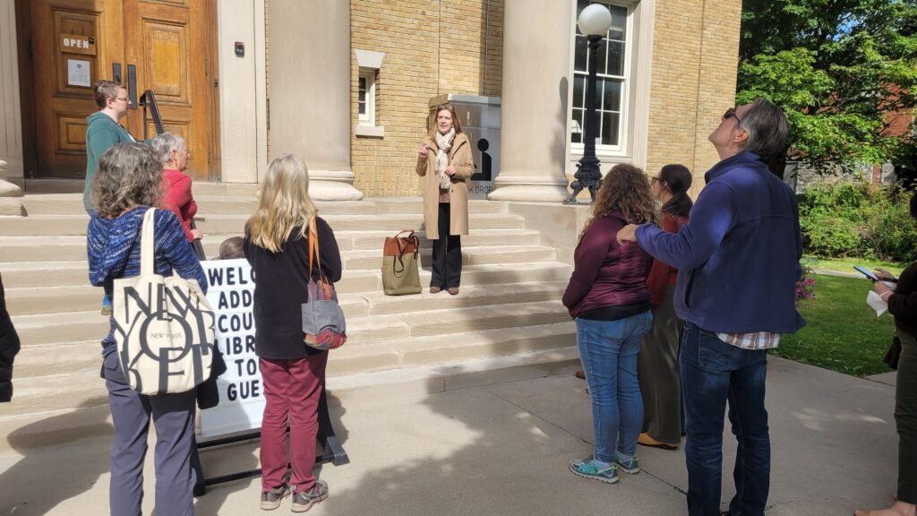Bixby Memorial Free Library Director Catherine Hays (center) greets VLA tour participants on the steps of the library in Vergennes.