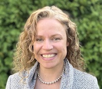 headshot of Oceana Wilson, smiling in front of a green background